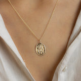 close up of model wearing white shirt and gold eternally friends pendant necklace