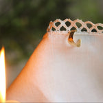 gold ear cuff on lace fabric with candle