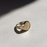 St christopher ring gold with an embossed design on a light gray surface