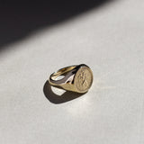 St christopher ring gold with an embossed design on a light gray surface