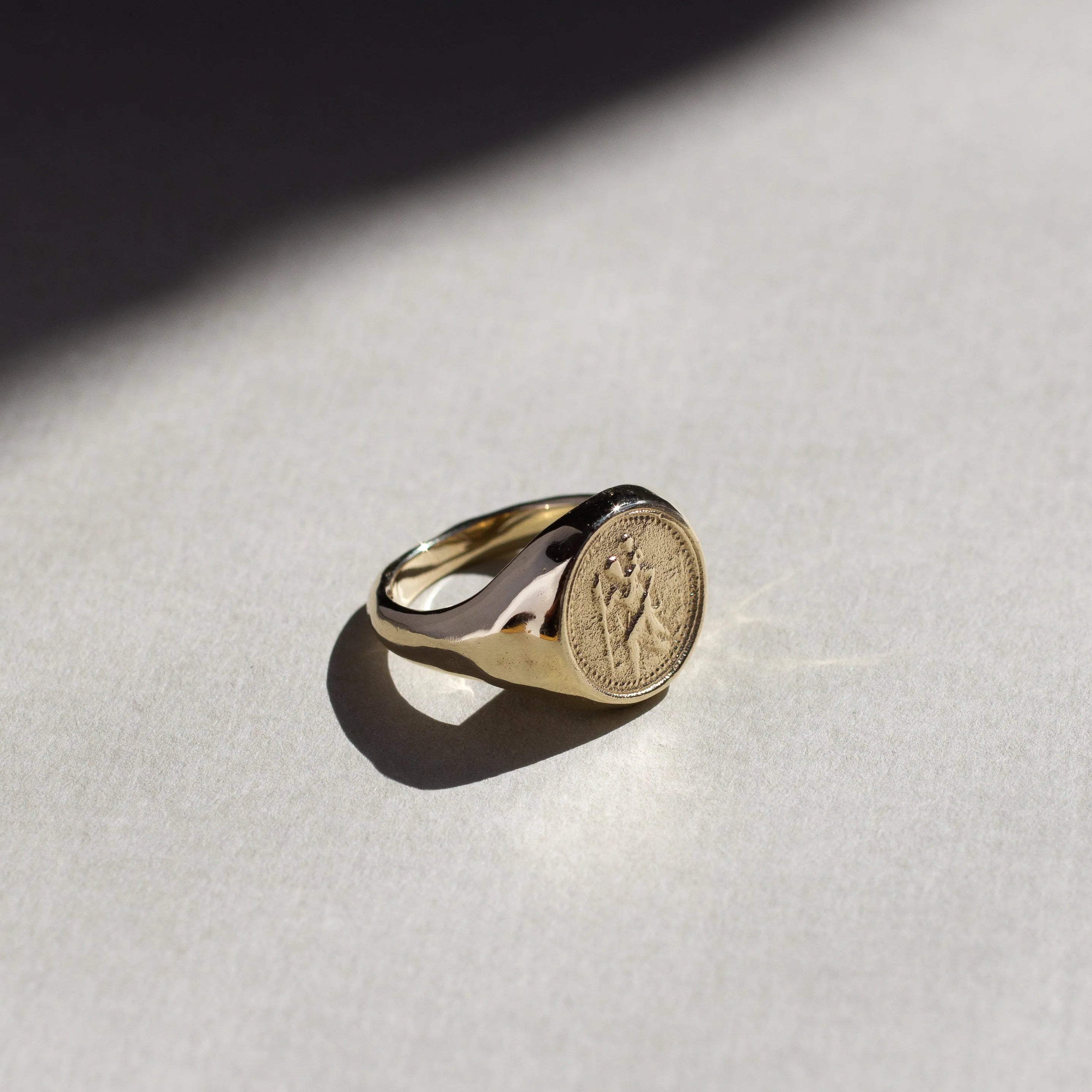 St christopher ring gold with an embossed design on a light gray surface