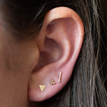 brunette model wearing triangle, triple dot and bar gold stud earrings