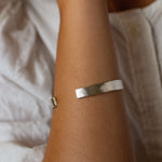 Silver bracelet on a person's wrist with a soft background