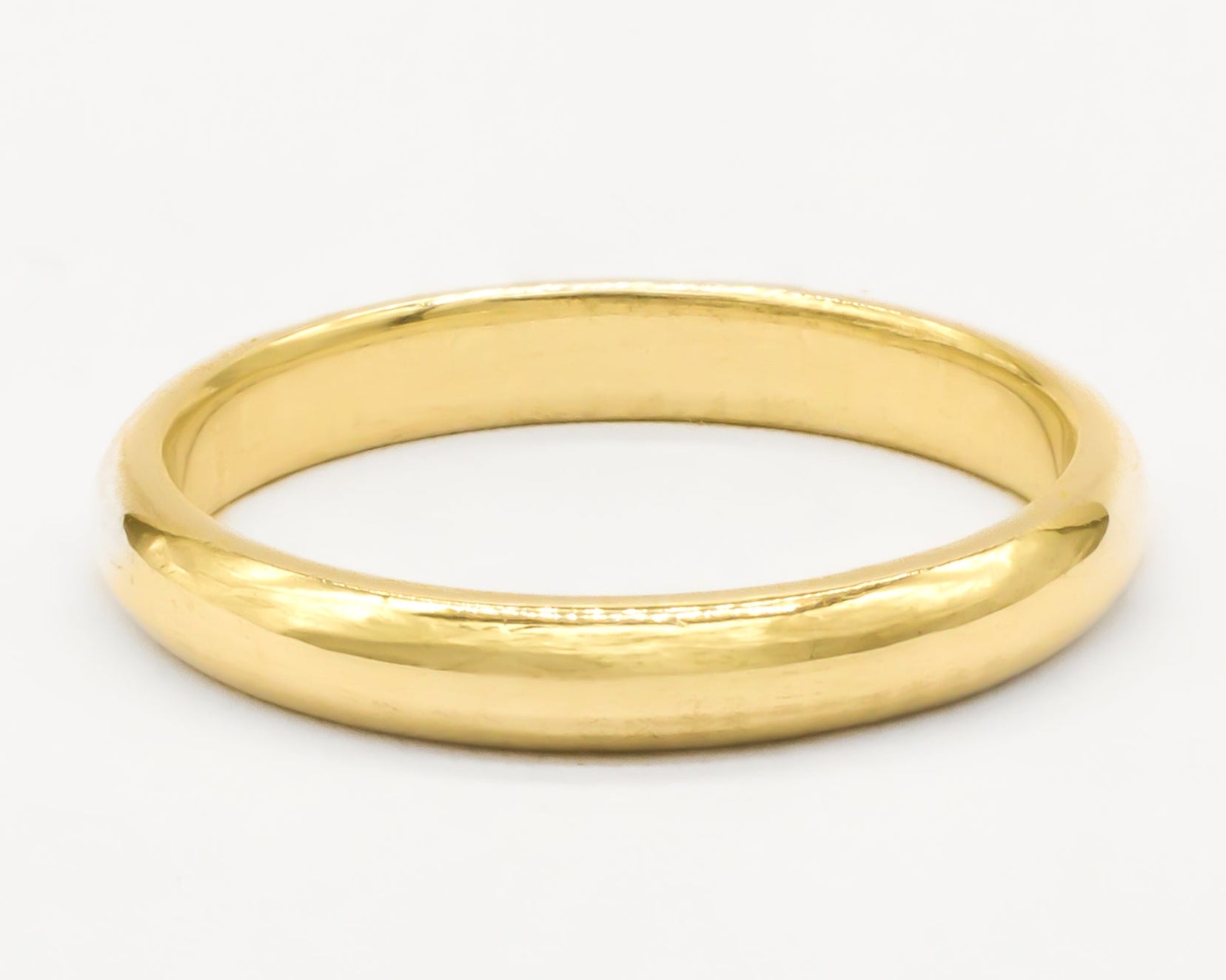 Gold polished wedding ring on a white background