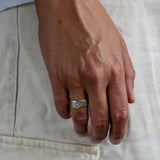 close up of raw band ring worn on mens hand