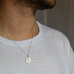 close up of silver saint christopher ring worn by male model