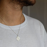 close up of silver saint christopher ring worn by male model