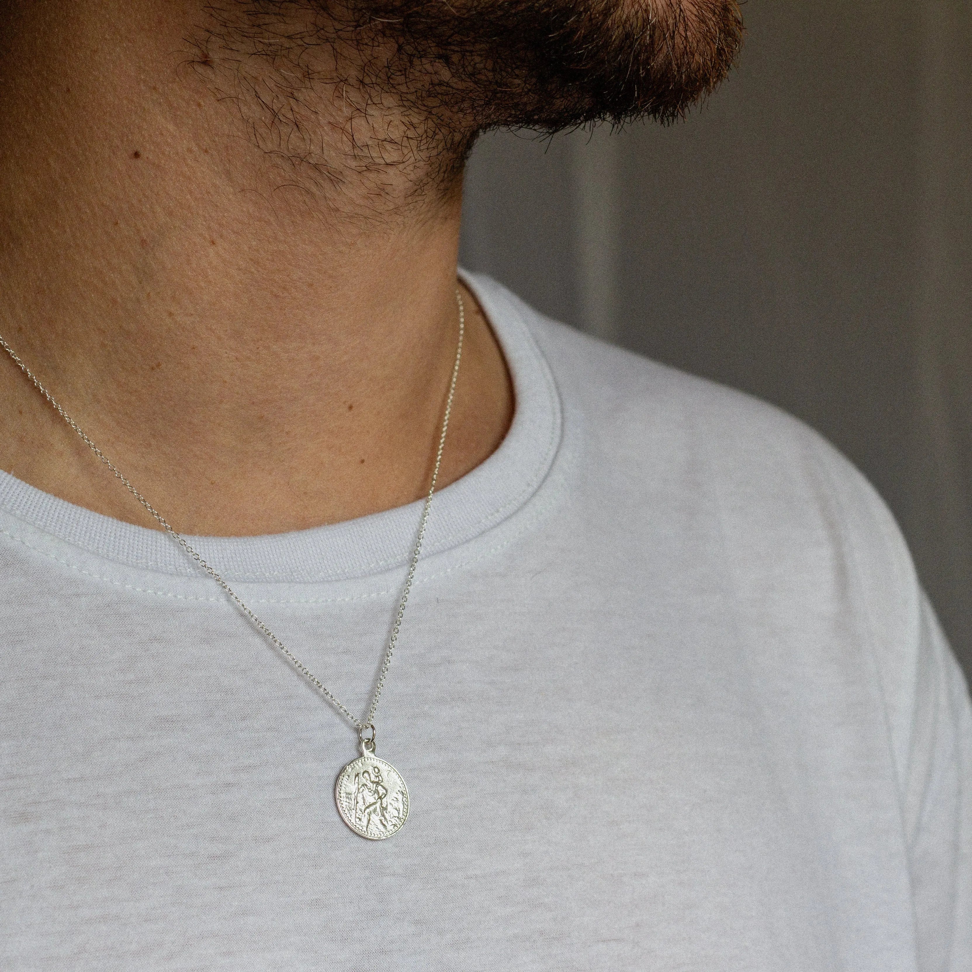 close up of silver saint christopher ring worn by male model
