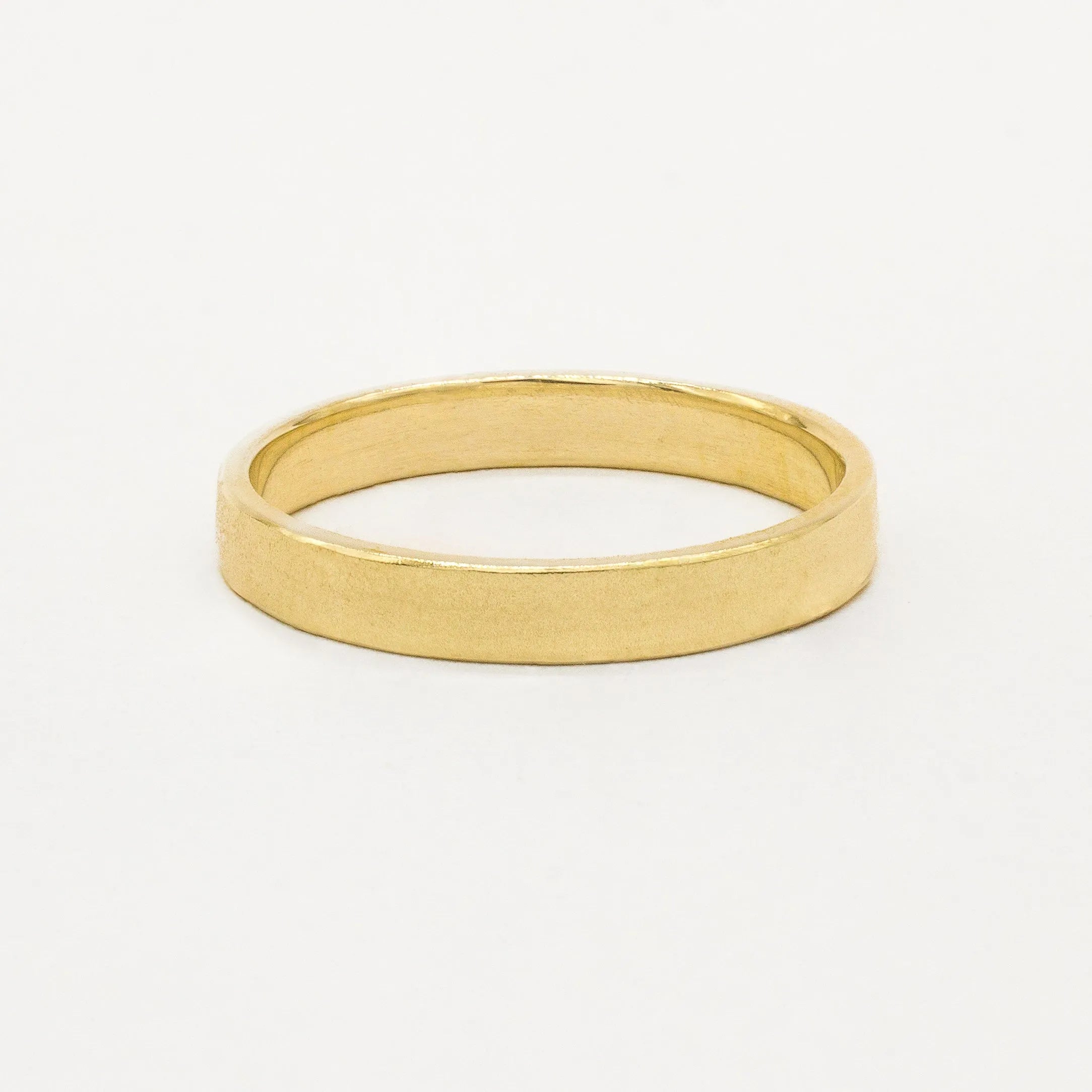 Gold satin flat wedding ring on a white background