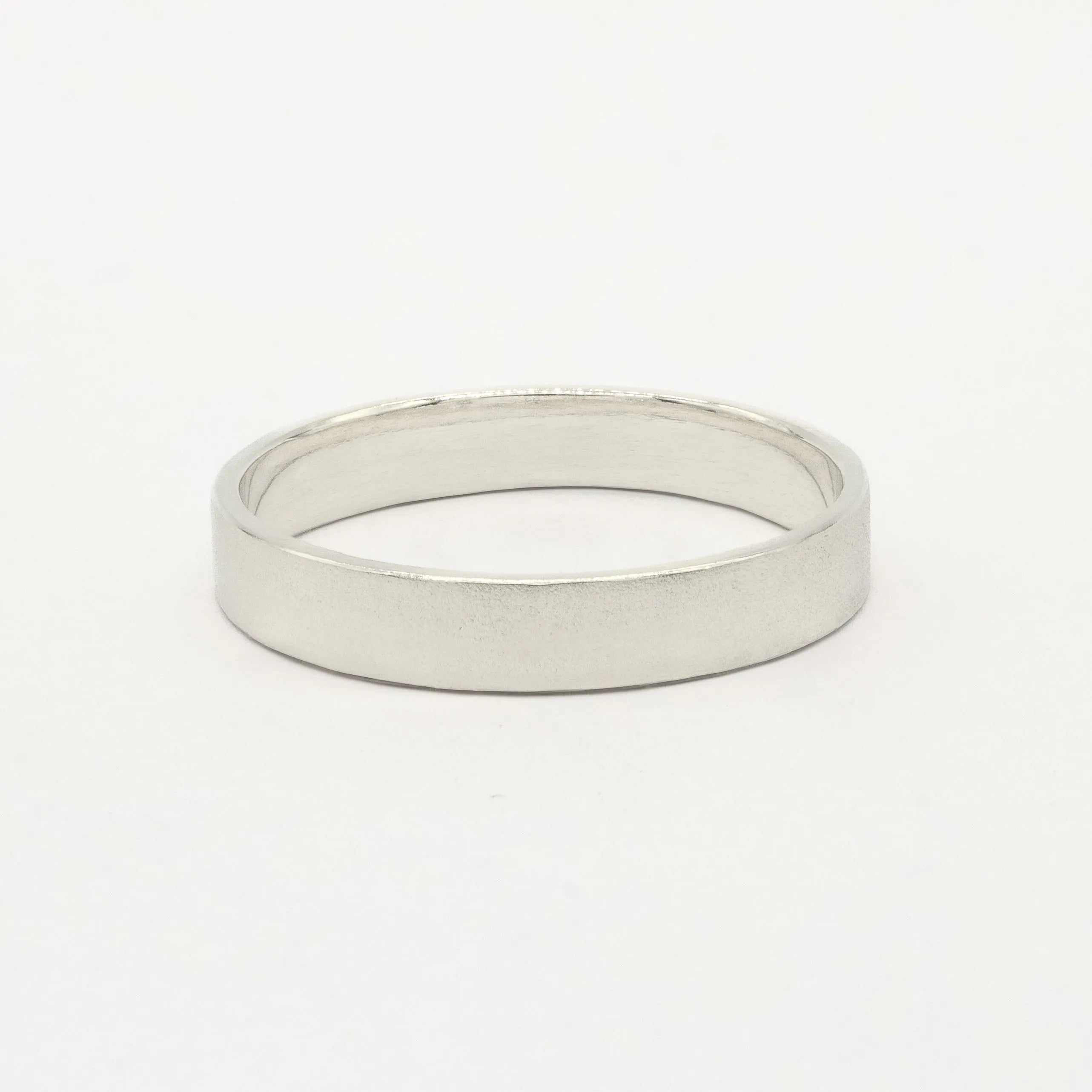 4mm wide white gold flat wedding ring with satin finish on white background