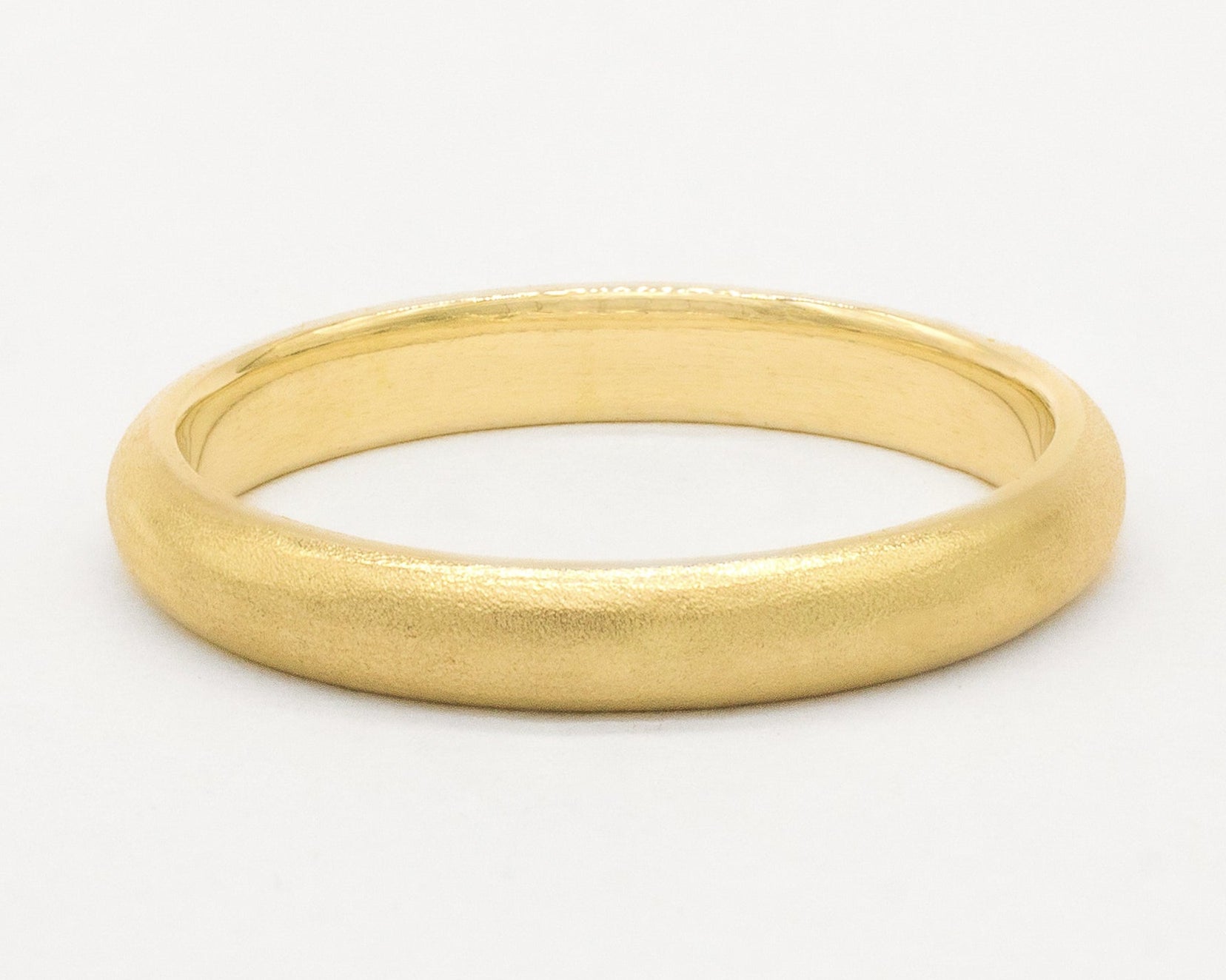 Gold satin wedding ring on a white background