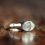 silver ancient pinkie signet ring with the letters g, b and d engraved in uppercase