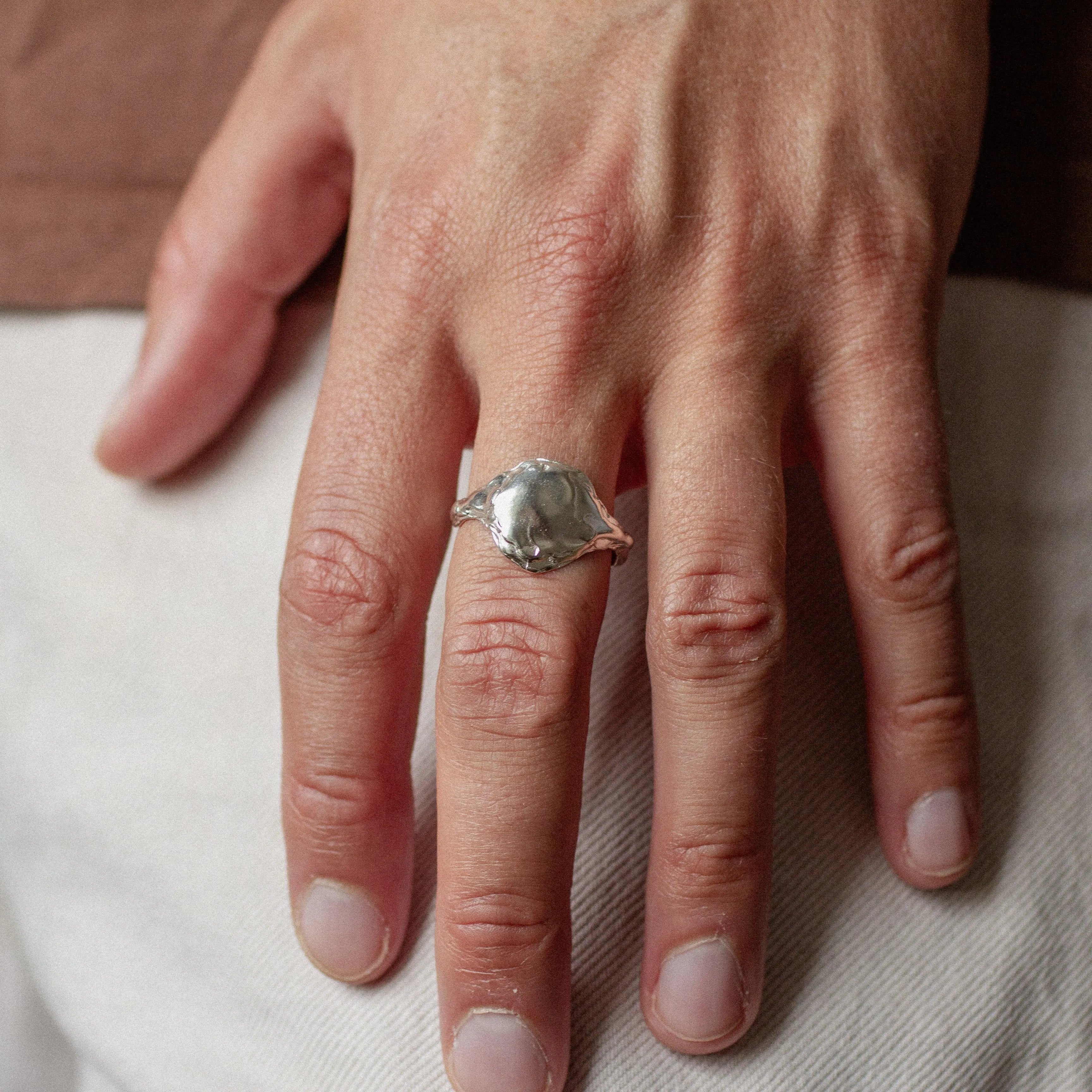 close up of male hand wearing silver full moon ring on middle finger