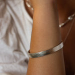 close up of arm wearing silver chunky bangle