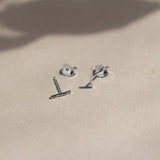 sterling silver hammered bar stud earrings with butterfly backs on beige surface with leaf shadows