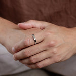 close up of hands wearing hammered silver ring