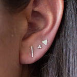 close up of model's ear with silver bar, triple dot and silver stud earrings