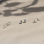 circle, pebble and bar silver stud earrings with leaf shadow
