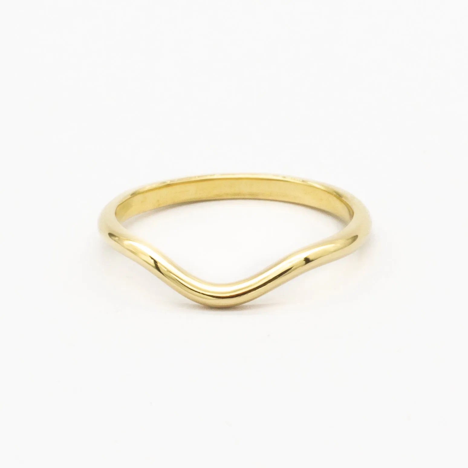 gold soft curved wedding ring with polished finish on white backhground