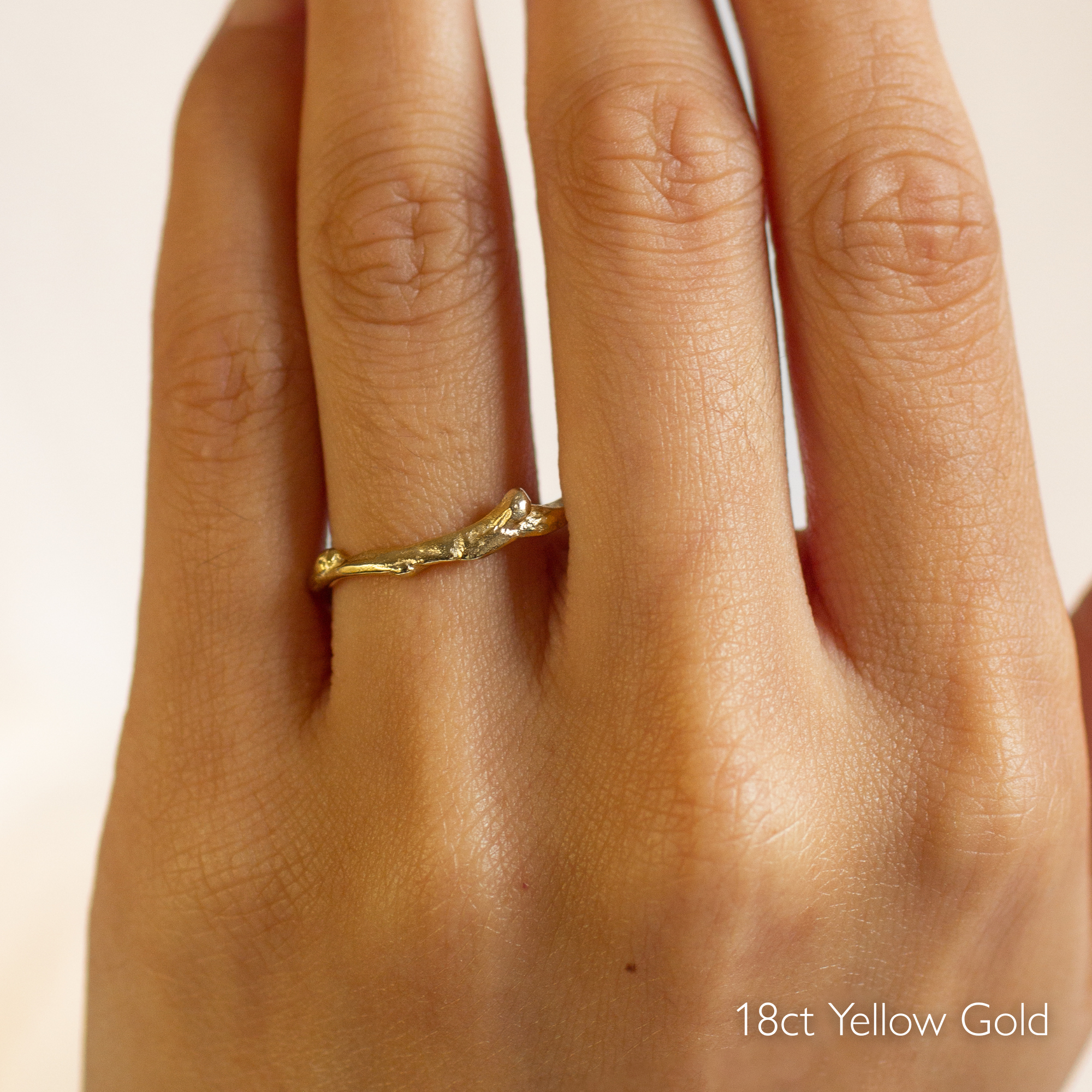 hand wearing tree branch shaped wedding ring in 18ct yellow gold