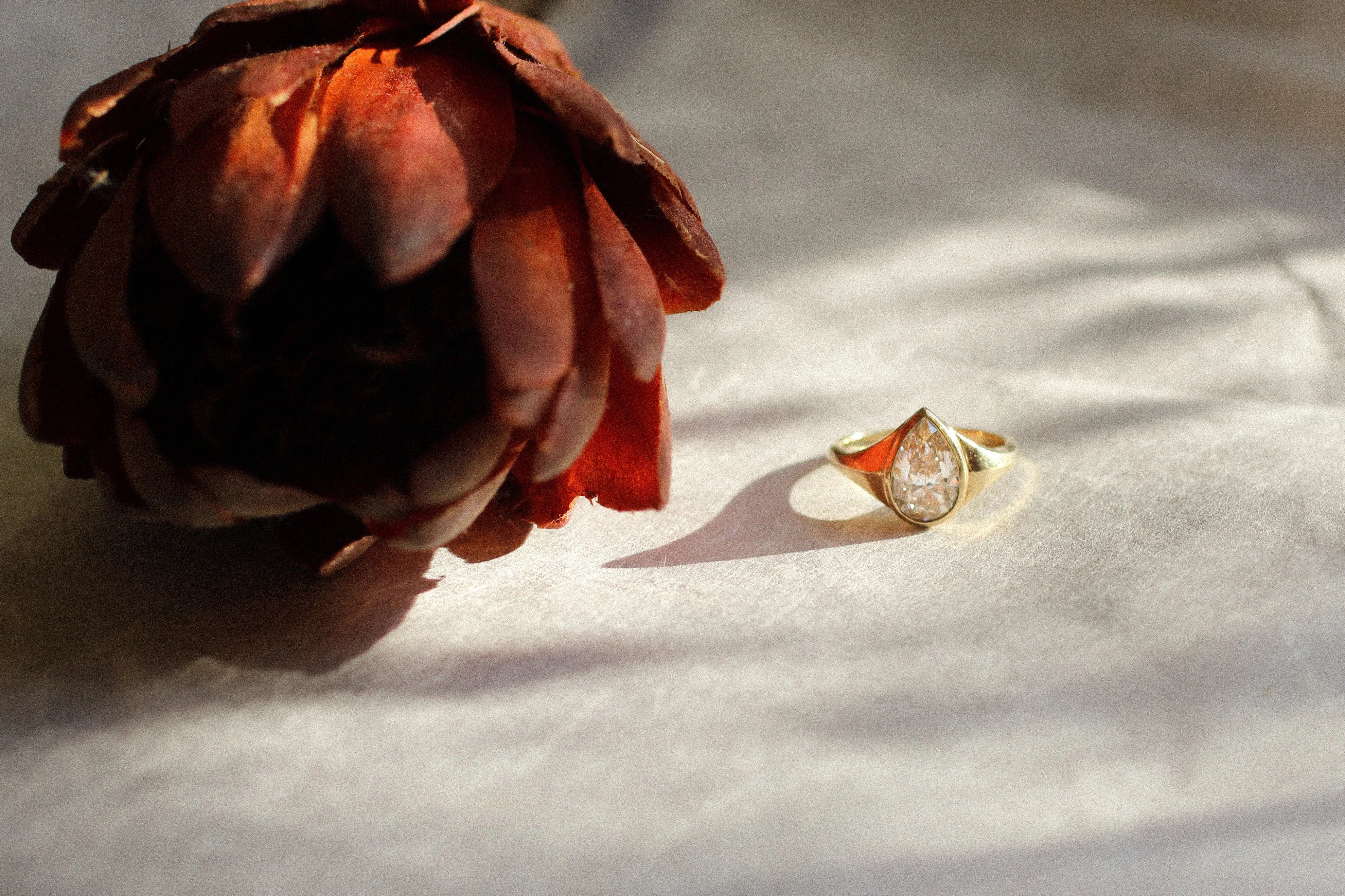 gold diamond pear engagement ring with flower and shadows