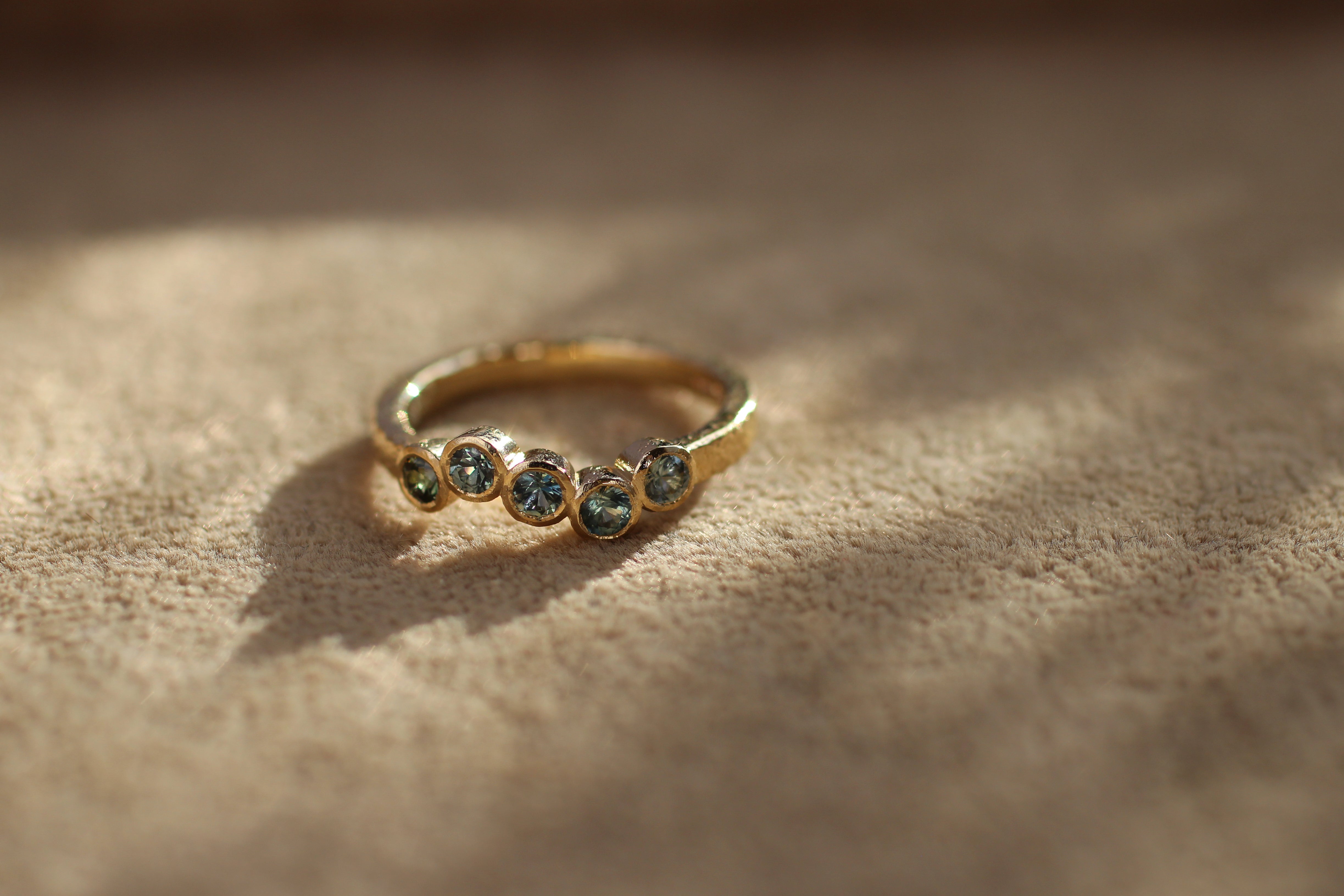 dainty engagement ring with bezel set sapphires
