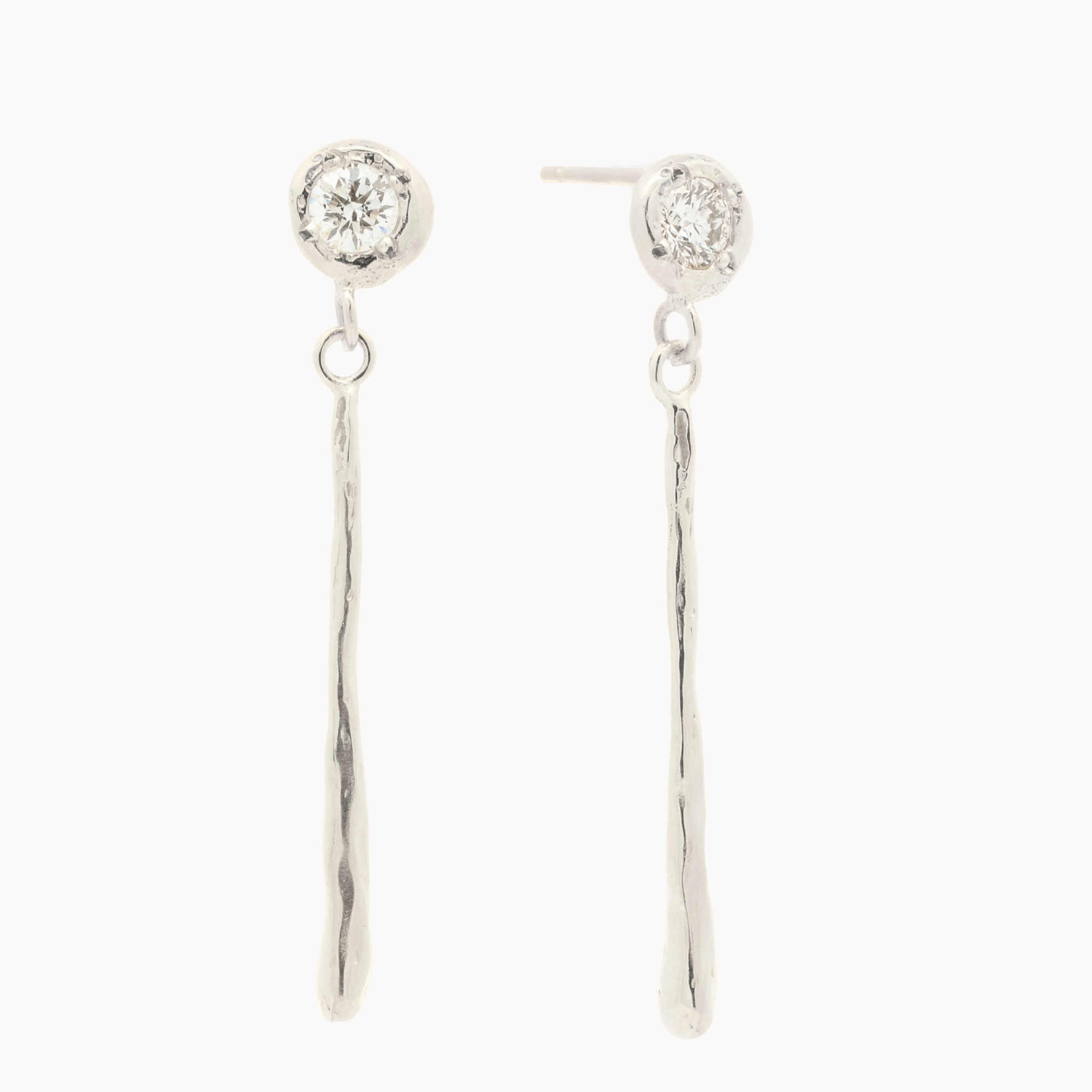 white gold earrings with round diamond stud and thin dangling molten bars on a white background