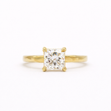 gold engagement ring with square princess cut diamond and textured flat band on a white background