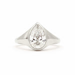 A pear-cut diamond ring set in a polished silver-colored metal band, shown against a plain white background.