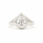 A pear-cut diamond ring set in a polished silver-colored metal band, shown against a plain white background.