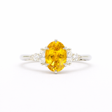 Ring with a yellow gemstone and diamond accents on a white background