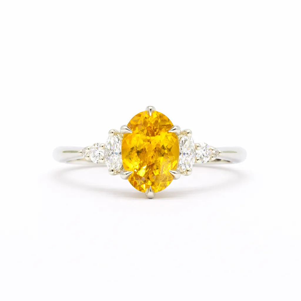 Ring with a yellow gemstone and diamond accents on a white background