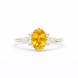 Ring with a yellow gemstone and diamond accents on a white background