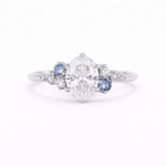 Cluster Oval Diamond and Blue Sapphire Engagement Ring on a white background