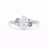 Cluster Oval Diamond and Blue Sapphire Engagement Ring on a white background