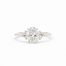 diamond engagement ring in white gold with large oval diamond and smaller scattered round diamonds on a white background
