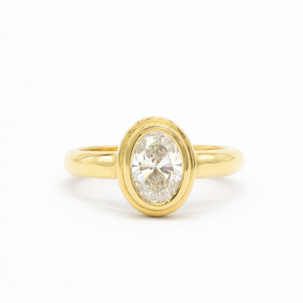 chunky gold engagement with a double bezel oval diamond on a white background
