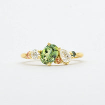 asymmetric engagement ring in lightbox with green and pink sapphires and lab-grown diamonds