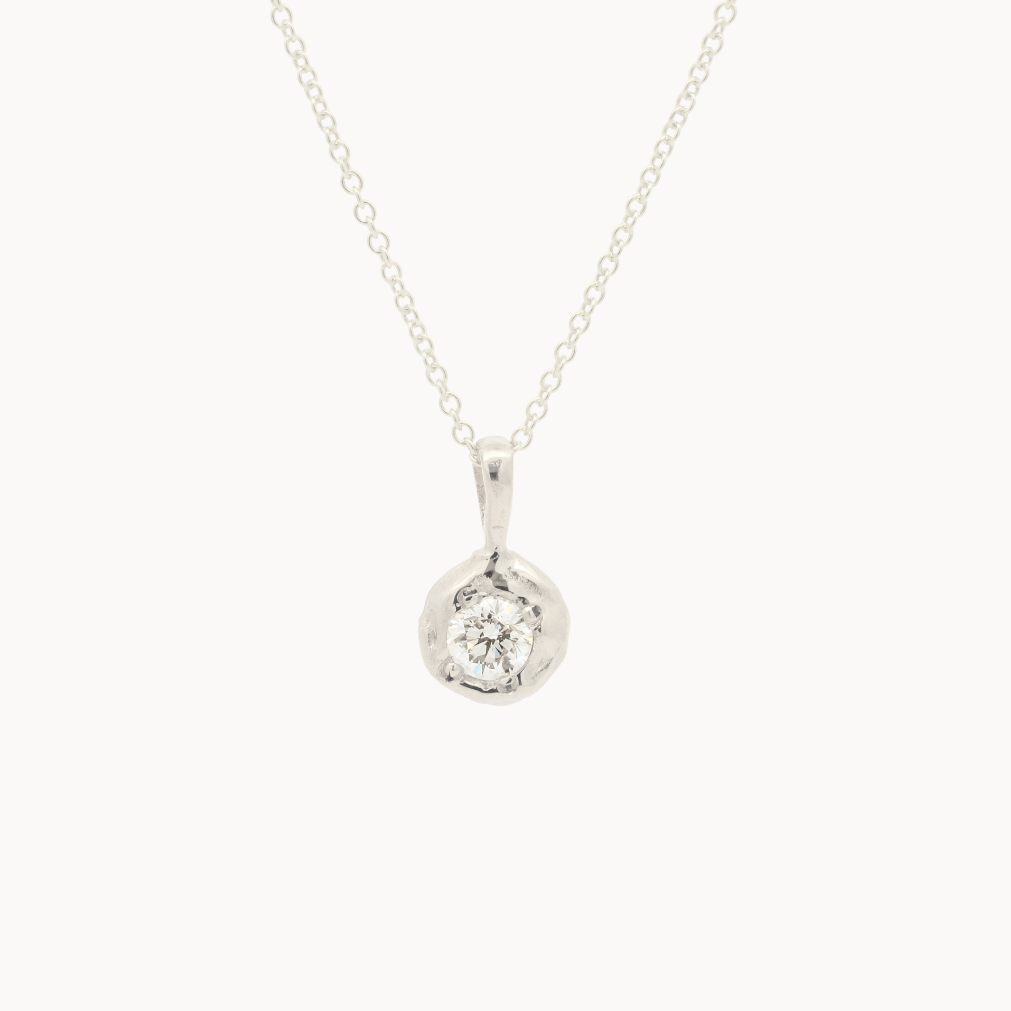 white gold pendant necklace with molten-effect gold and round diamond on a white background
