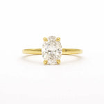 oval diamond solitatire engagement ring with solid gold band on a white background