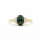 blue green oval sapphire engagement ring with 6 accent stones on a white background