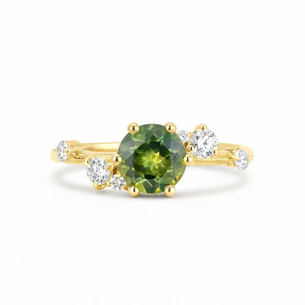 Gold ring with a green gemstone and smaller diamonds on a white background