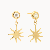gold diamond dangle earrings with molten texture and sun-shaped charms on a white background