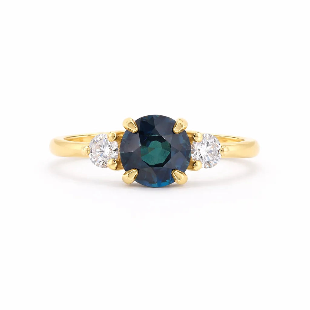 Round Deep Blue Sapphire Trilogy Engagement Ring with round diamonds on a white background
