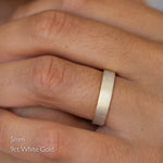 9ct white gold ring on a person's finger with text indicating size 5mm and material 9ct white gold.