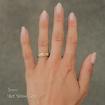 A hand wearing a textured yellow gold band ring, with text overlay indicating '5mm 18ct Yellow Gold'.