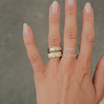 hand wearing two tree-bark textured wedding rings in gold in 5mm and 6.7mm to show width comparison