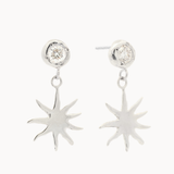 White gold diamond stud earrings with sun-shaped charms hanging off them against a white background