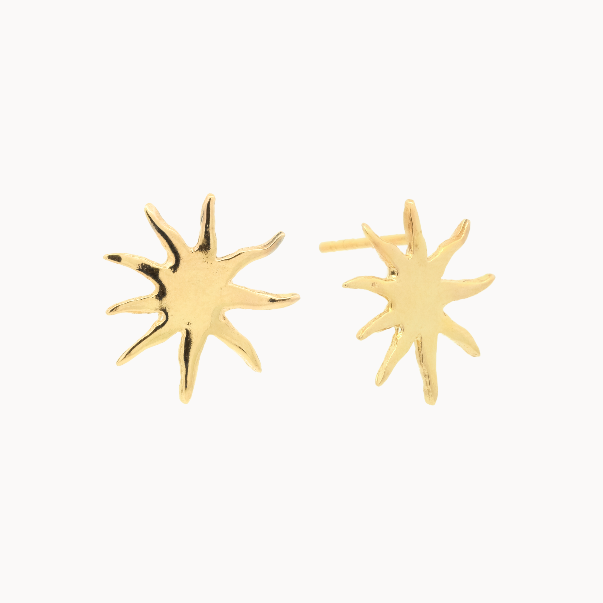 Gold sun-shaped stud earrings on a white background