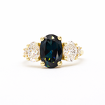 large oval sapphire and diamond engagement ring on white background